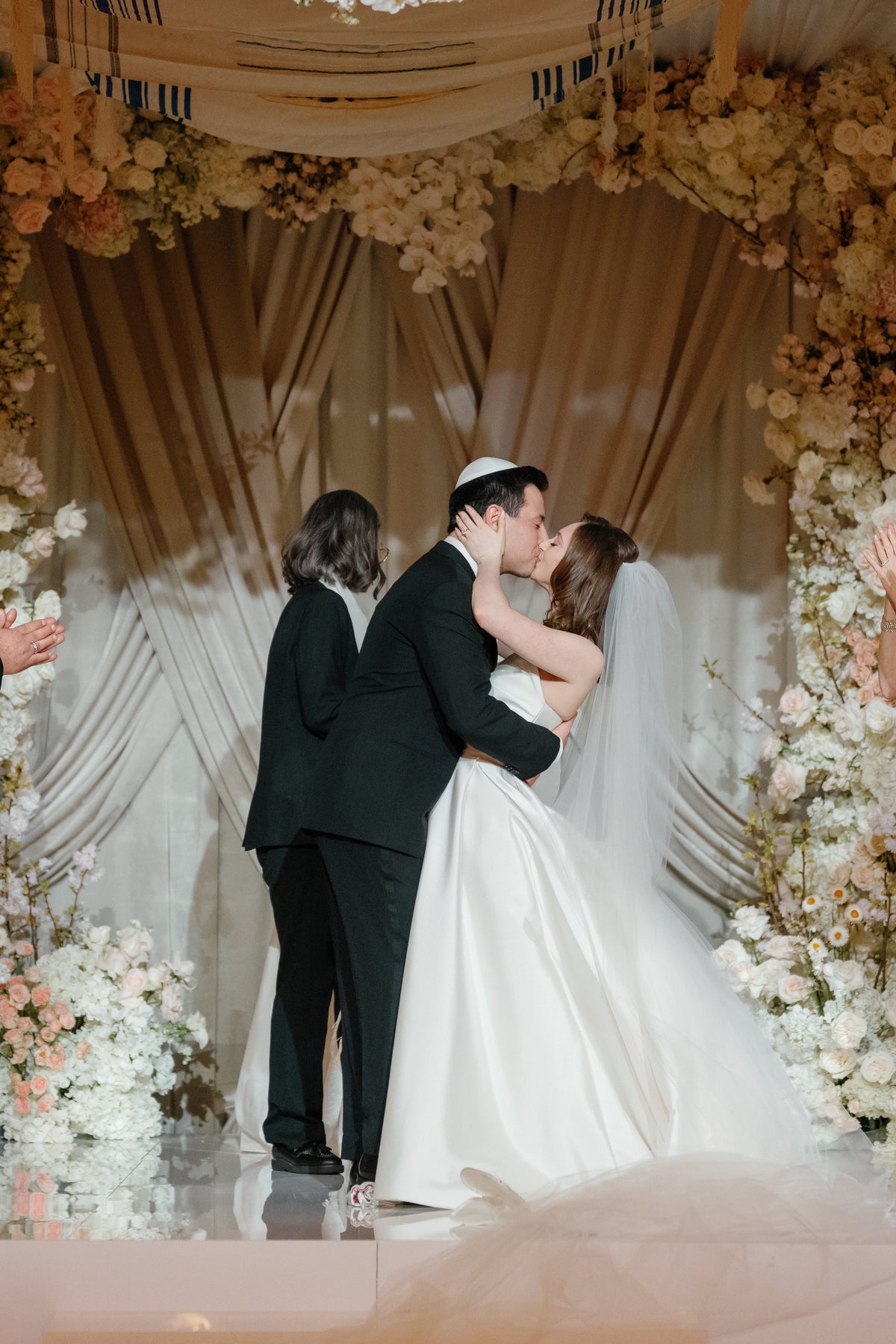 A couple beneath the chuppah as the glass breaks